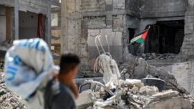 A man looks at a tattered Palestinian flag flying in a ruined building in Khan Yunis in the southern Gaza Strip on September 16, 2024. 