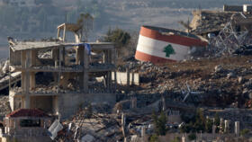 An Israeli flag on a destroyed building, and a Lebanese flag painted on a damaged building in the southern Lebanese village of Meiss El-Jabal on November 25, 2024.