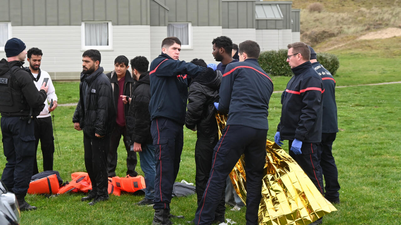 Firefighters help a migrant put on an emergency blanket after being rescued following a failed attempt to cross the English Channel to reach Britain, on the beach of Sangatte, France, on Dec. 4, 2024.