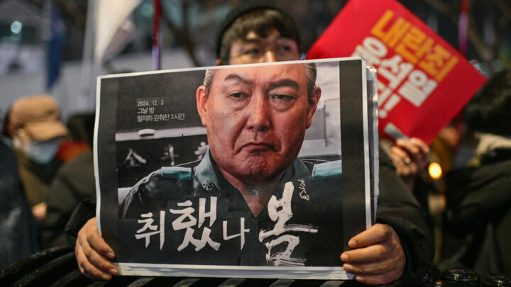 A protester holds a poster with an image of South Korea President Yoon Suk Yeol during a rally calling for his ouster in Seoul on December 5, 2024.