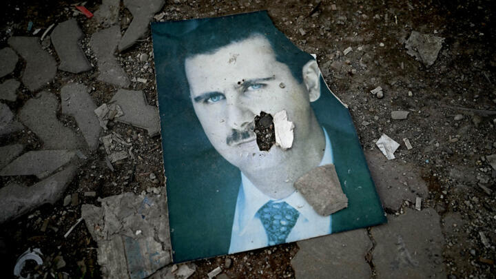 Un portrait du président syrien déchu Bachar al-Assad, abîmé, sur le sol, dans la ville portuaire de Lattaquié, dans l'ouest de la Syrie, le 15 décembre 2024.