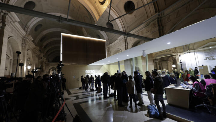 People wait outside the Paris Special Assize Court for the verdict in the case against eight people charged in connection with the jihadist beheading of Samuel Paty in 2020 to be announced.