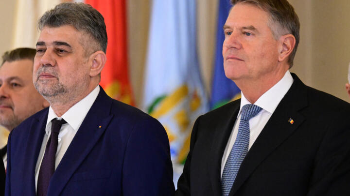Romania's President Klaus Iohannis and Prime Minister Marcel Ciolacu stand after the swearing in ceremony at the Romanian Presidency headquarters, in Bucharest, Romania, December 23, 2024.