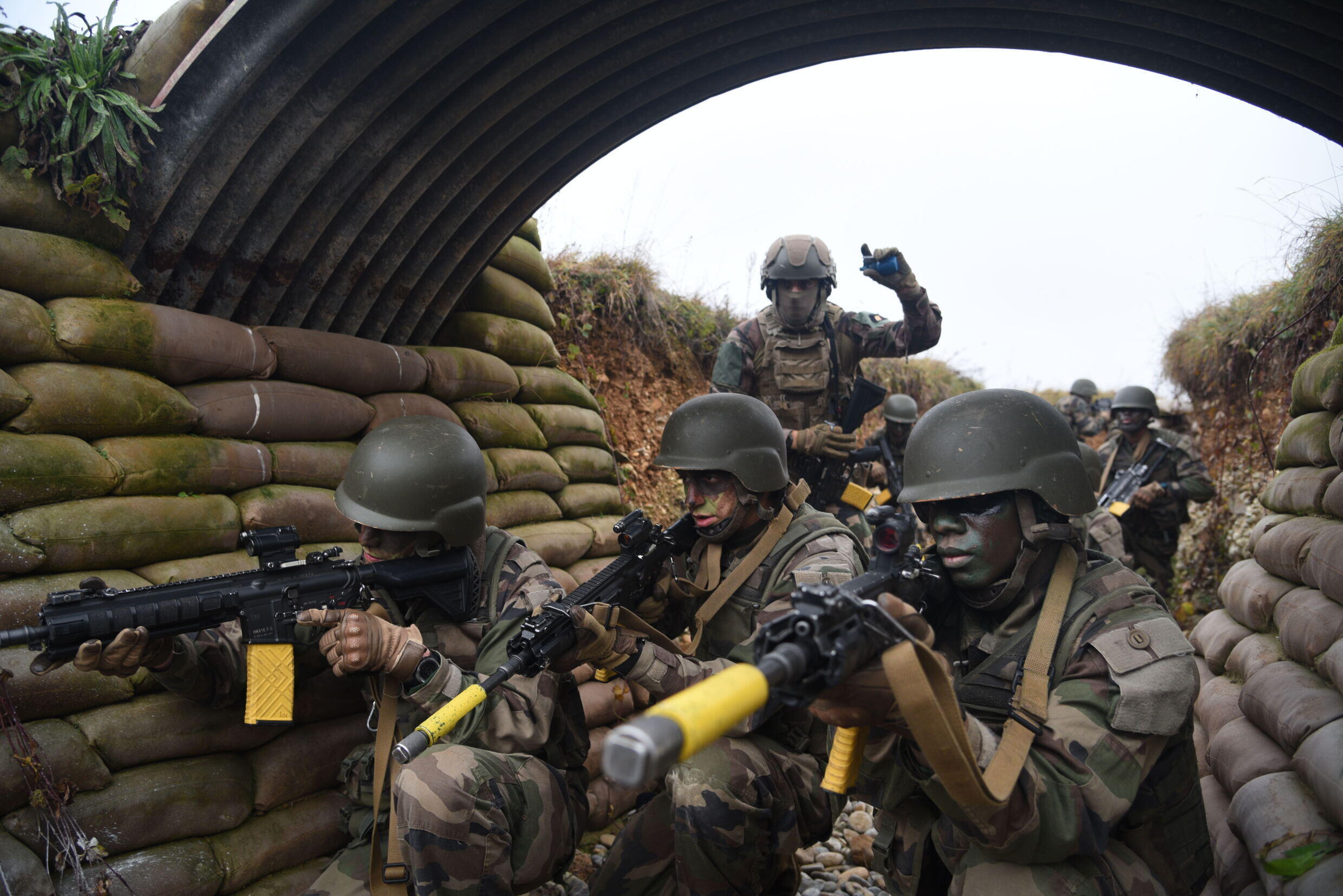 A soldier prepares to throw a grenade into a blind spot in the trench, while his team-mates are in a support position.
