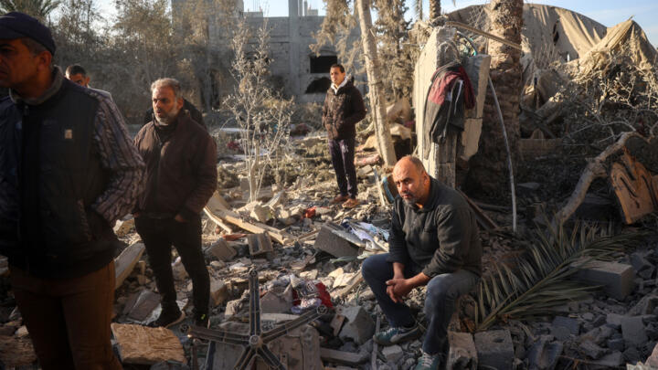 A relative of the Abu Samra family looks on as Palestinians search for survivors after a strike on their home in central Gaza.