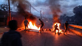 Protesters gather next to a burning barricade in Maputo on December 23, 2024.