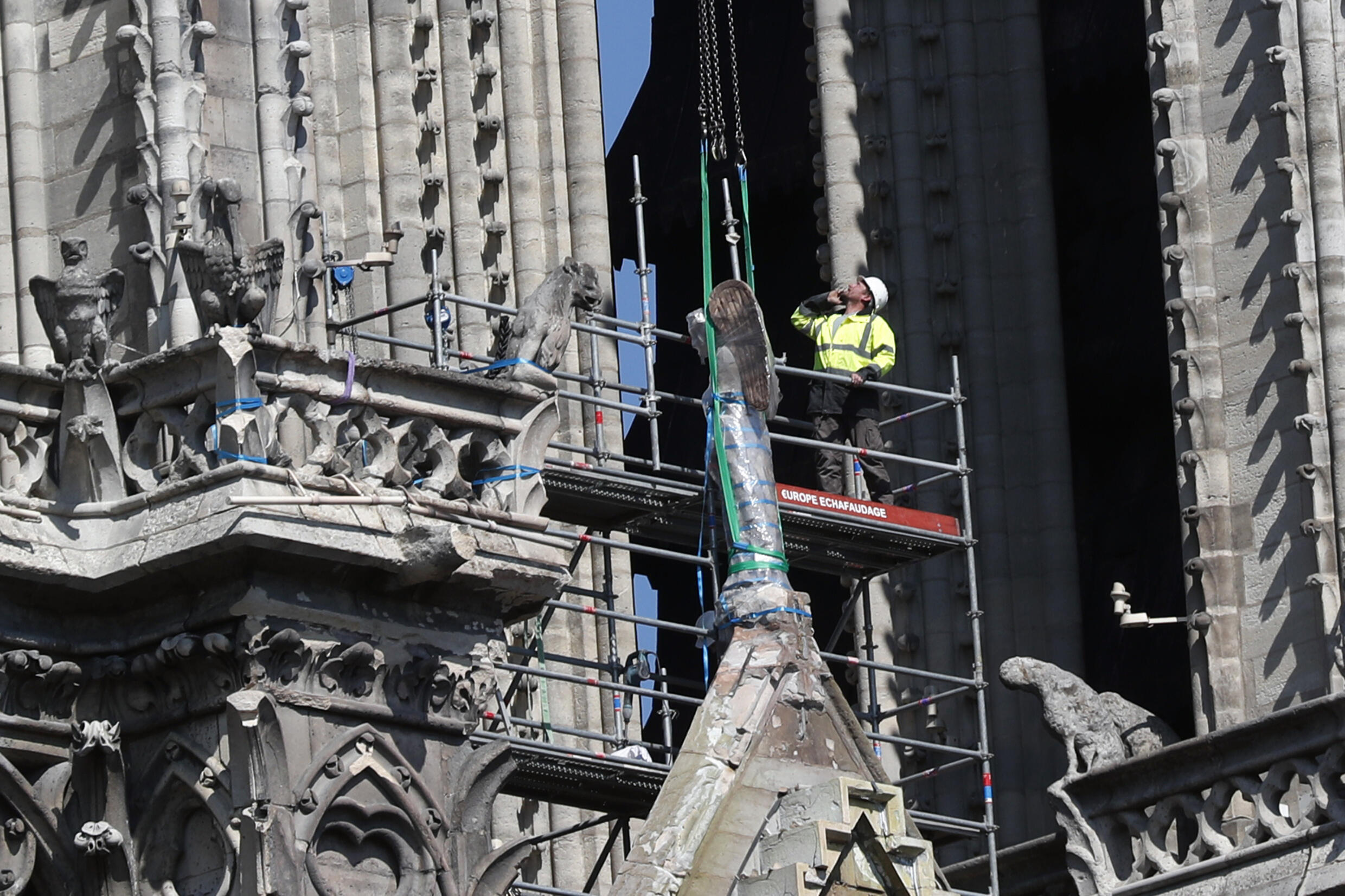 A worker prepares to remove a statue from the damaged Notre Dame cathedral on April 19, 2019.