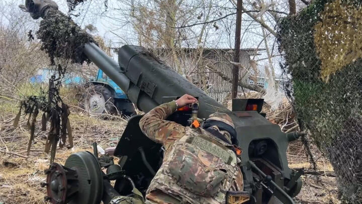 In this photo taken from a video released by Russian Defense Ministry press service on Friday, Nov. 29, 2024, Russian serviceman aims a D-30 howitzer towards Ukrainian positions in Kursk region.