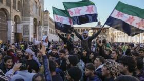 Crowds chant slogans and wave the new Syrian flag as they gather for Friday prayers at Umayyad mosque in Damascus, Syria, on Friday, December 13 2024.