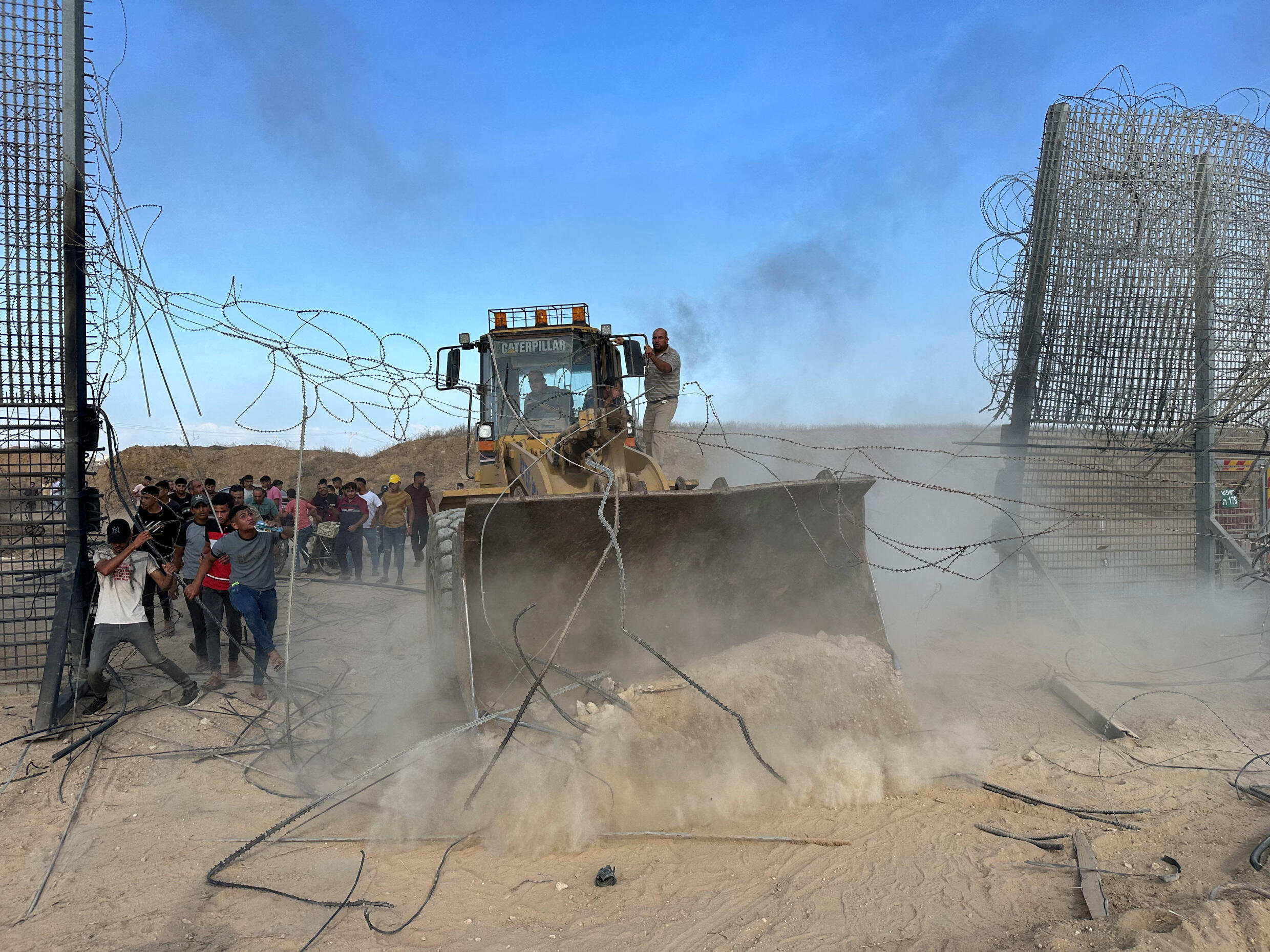 Palestinians break through the Israel-Gaza border fence on October 7, 2023, as gunmen infiltrated areas of southern Israel.