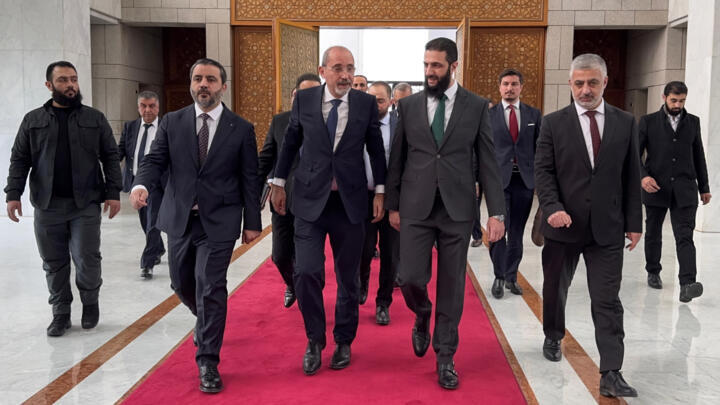 Jordanian Foreign Minister Ayman Safadi (C-L) is received by new Syrian leader Ahmed al-Sharaa (C-R) in Damascus on Monday.