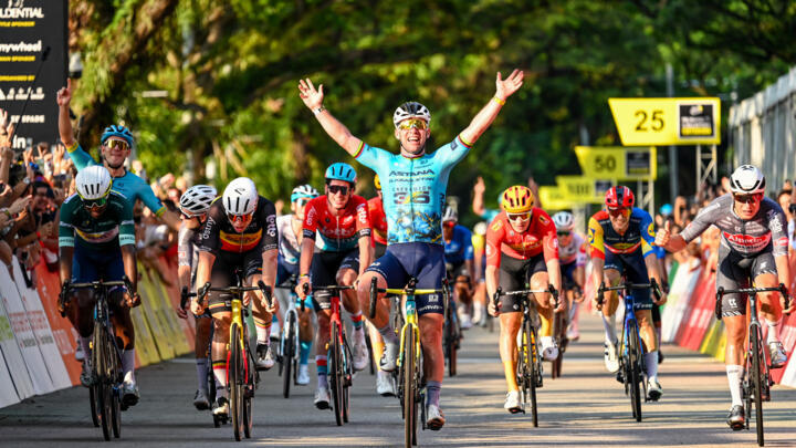 One last wave: Mark Cavendish (C) celebrates as he crosses the line to win his farewell race, the  Singapore Criterium