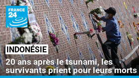 Un homme dépose des fleurs devant le Mur-mémorial du tsunami à Ban Nam Khem, en Thaïlande, le 26 décembre 2024.